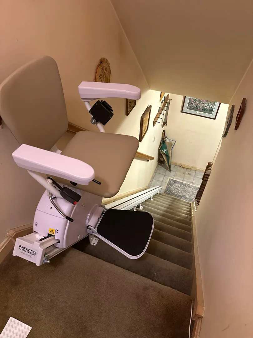 Curved stairlift parked at the top landing of a staircase in a Pennsylvania home