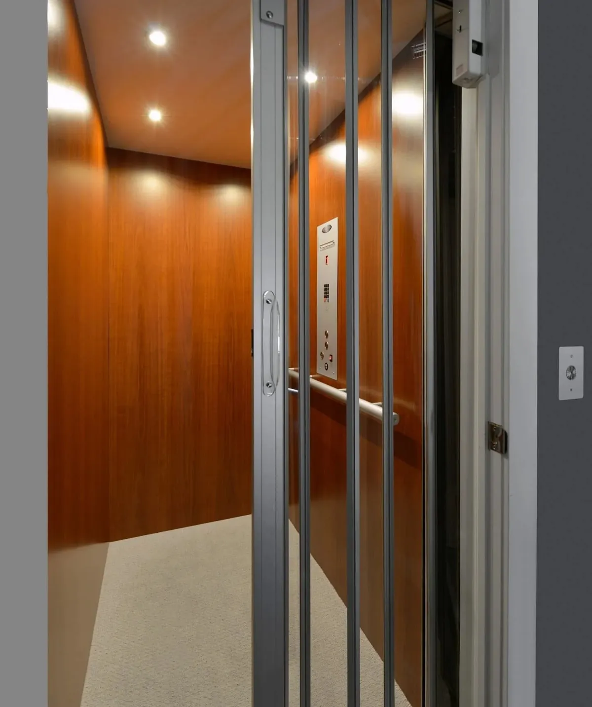 Savaria elevator cab with wood panels and recessed ceiling lighting