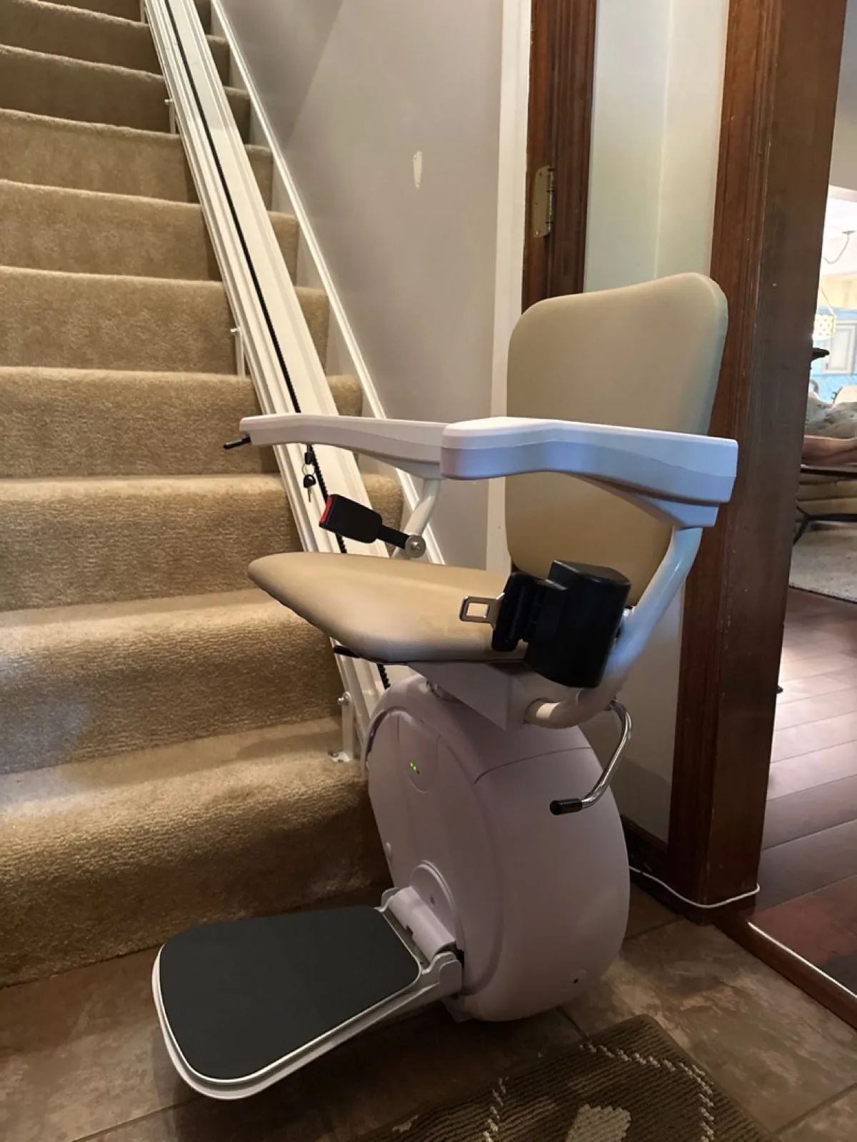 Savaria K2 stairlift on a carpeted staircase in a wood-paneled stairwell
