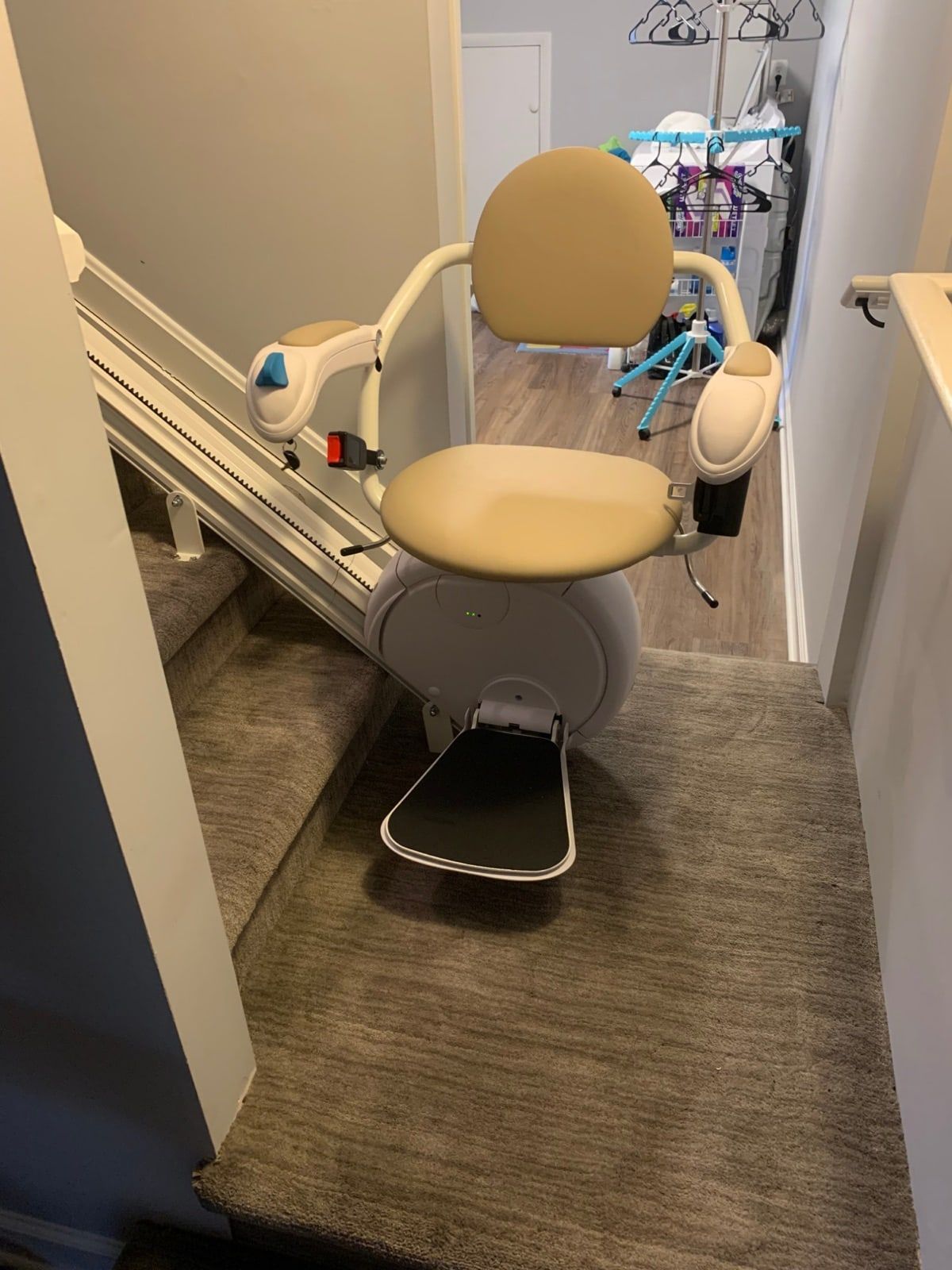 Savaria K2 stairlift at a landing with a carpeted staircase behind it
