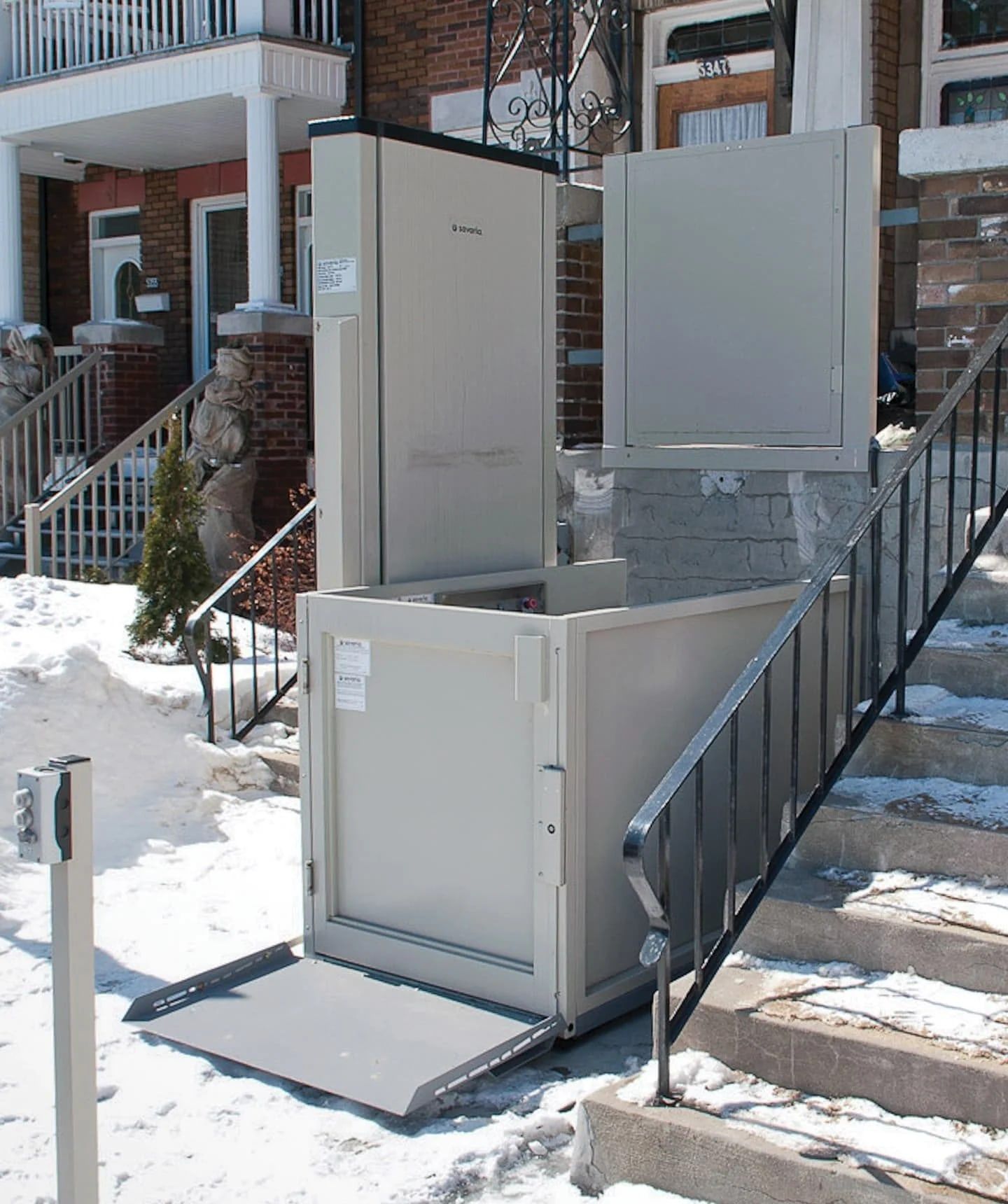 Outdoor open-platform wheelchair lift at a home porch