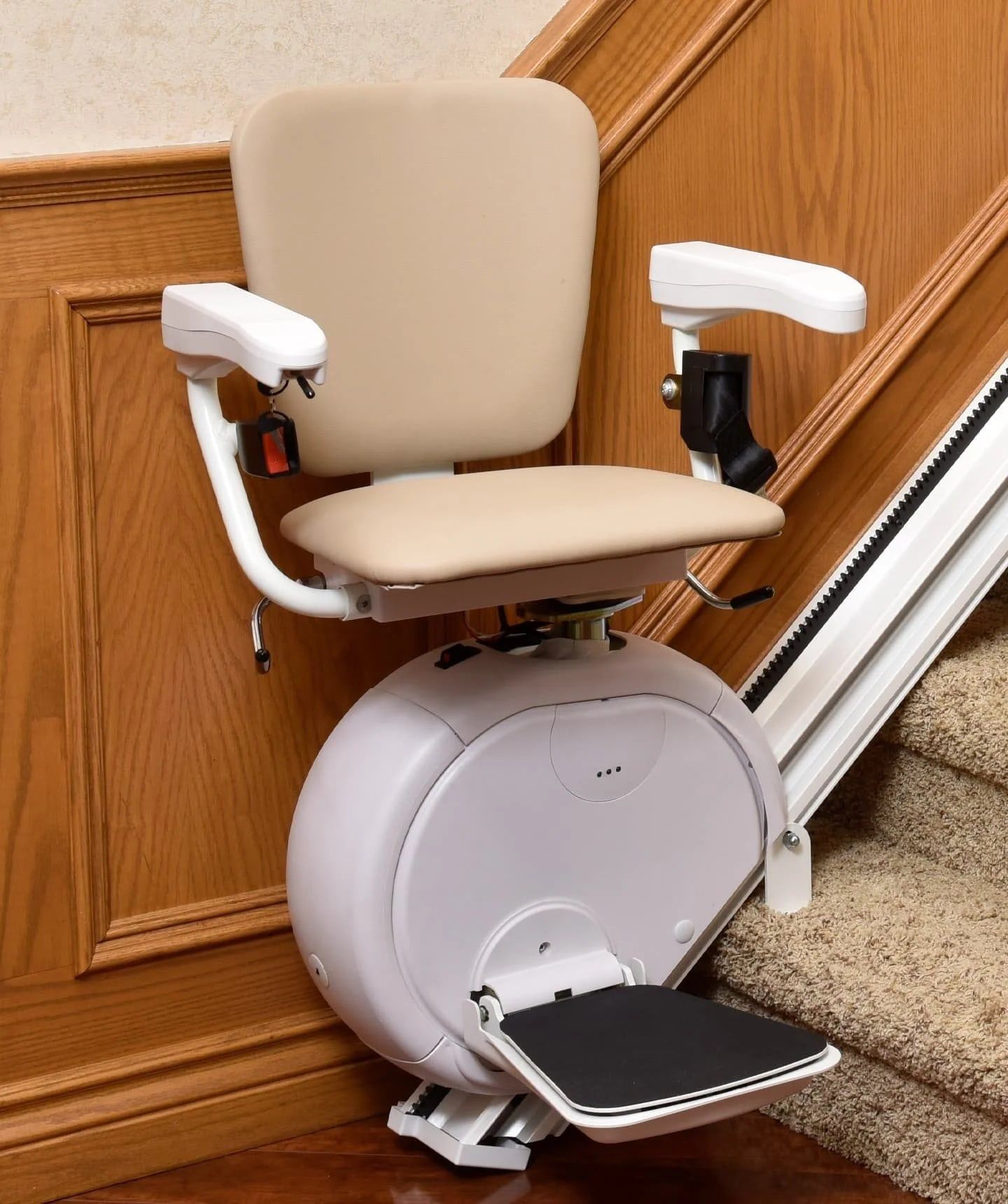 Savaria K2 straight stairlift with beige seat at the bottom of a staircase