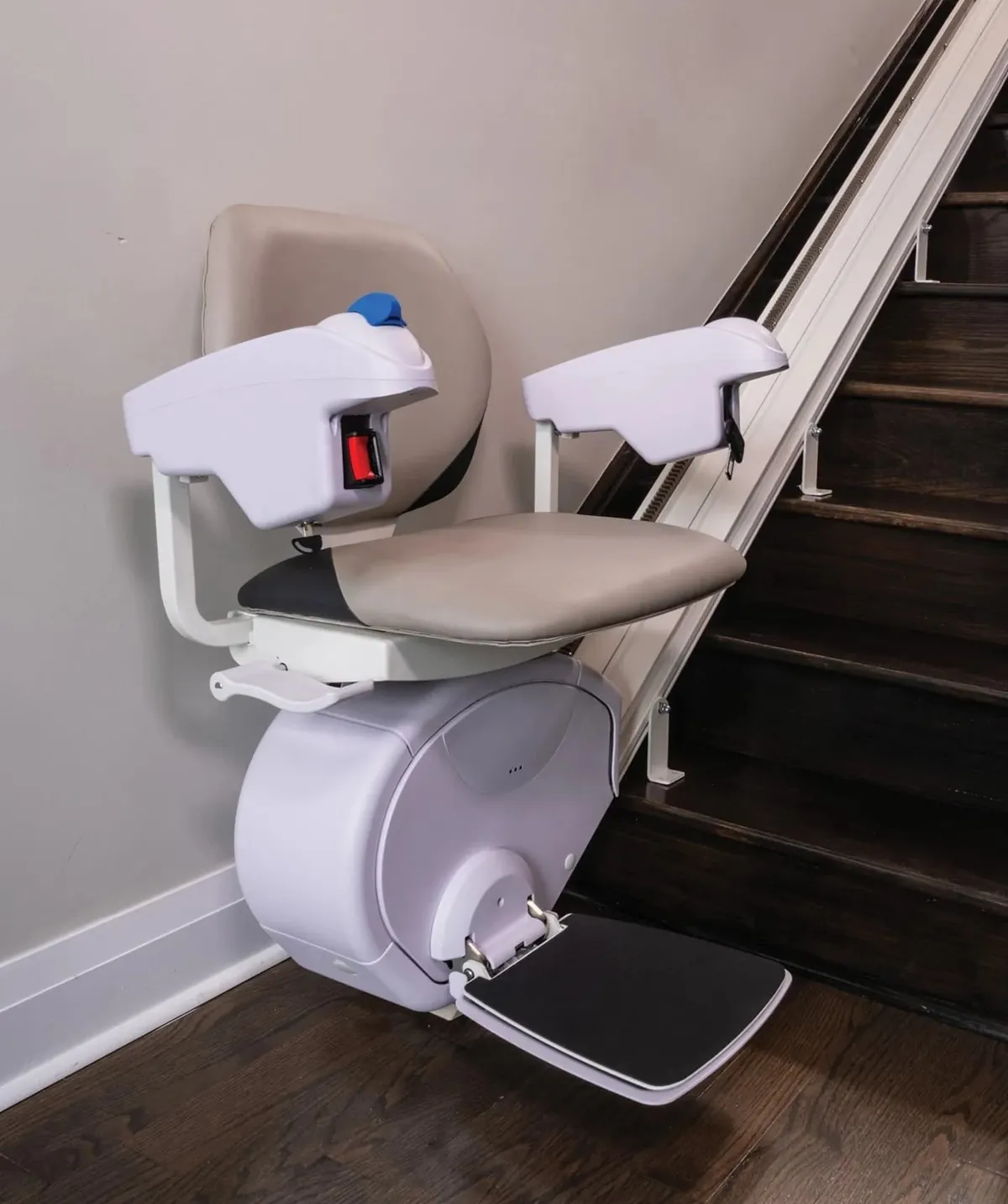 Technician servicing a stairlift drive unit on a staircase