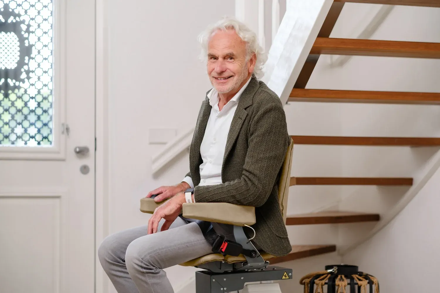 Harmar Curved Stairlift with Elderly Man smiling waiting to ride it up.
